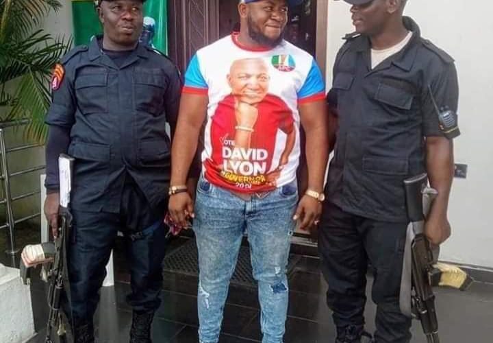 Photo Shows Arrested Notorious Kidnapper, John Ewa, Rocking Ruling APC Campaign T-shirt, Posing With Security Operatives